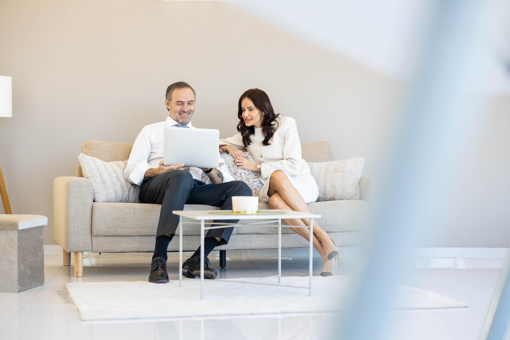 Agent imobiliar discutând cu proprietarii într-un living luminos